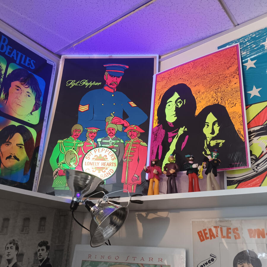 A couple of Beatles blacklight posters, lit with a blacklight.